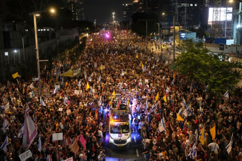 Una gran multitud de personas caminan en una calle por la noche