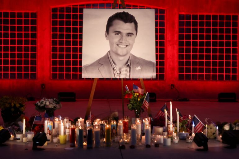 Las velas y las flores se colocan cerca de una imagen de Charlie Kirk