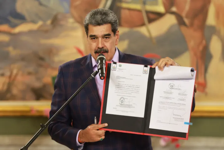 El presidente de Venezuela, Nicolás Maduro, sostiene una carpeta con un marco de defensa nacional aprobado por la Asamblea Nacional de Venezuela.