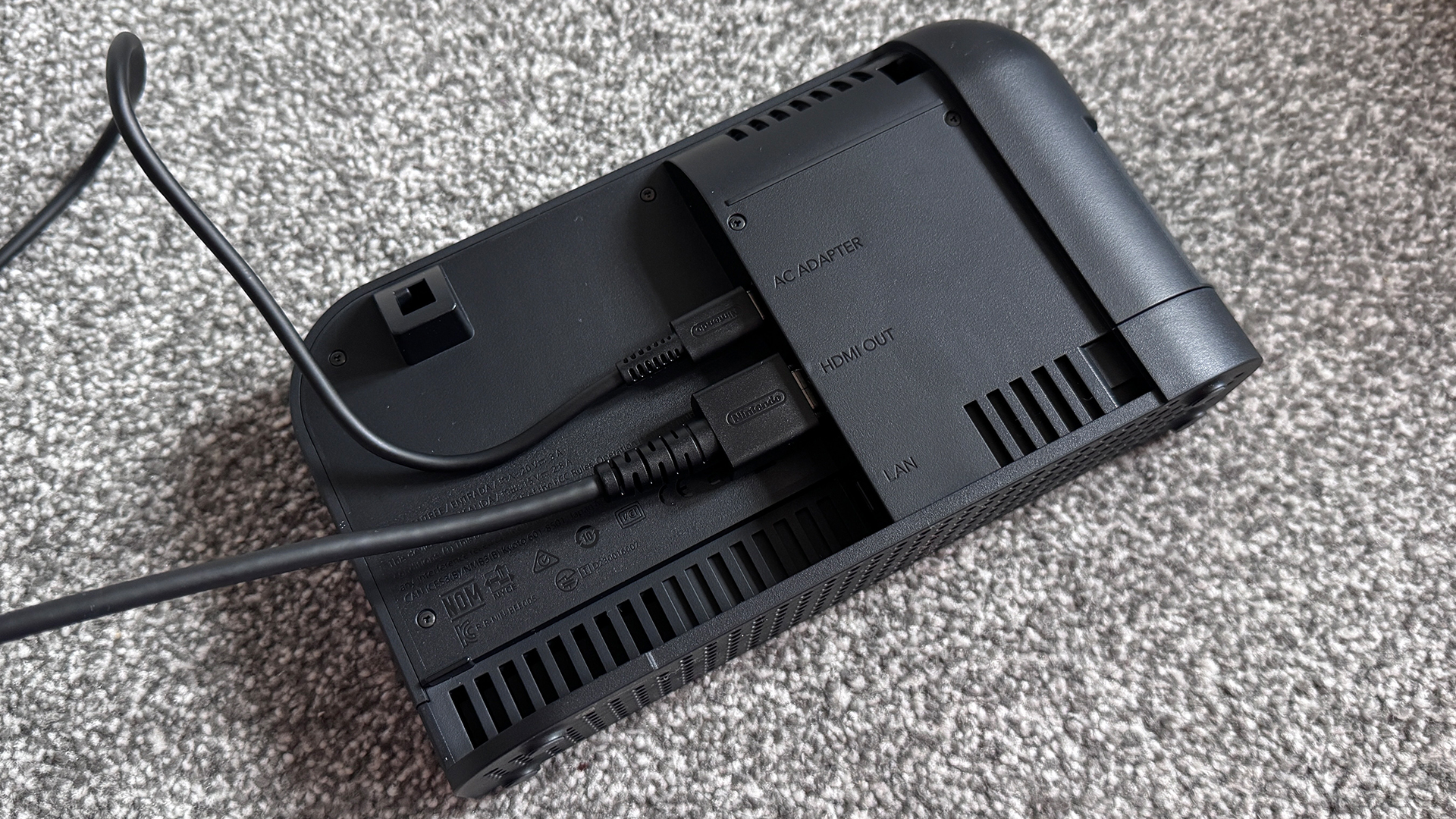 La base Nintendo Switch 2 con los cables de alimentación y HDMI conectados y el panel trasero retirado