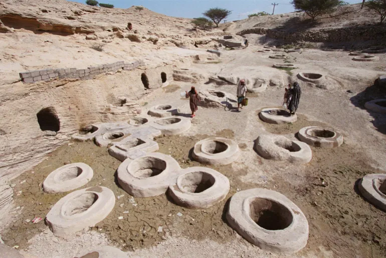 Los iraníes recolectan agua potable en los pozos de Tala (oro) en la aldea de Laft en la isla de Qeshm el 17 de febrero de 2001. El área contiene 366 pozos, el número de días de un año bisiesto, que fueron excavados hace aproximadamente 2.000 años. Un centenar de pozos siguen funcionando. La isla de Qeshm, en la provincia de Hormozgan, en el sur de Irán, se encuentra a 1.060 kilómetros al sureste de Teherán. (PELÍCULA) AFP PHOTO/Henghameh FAHIMI (Foto de HENGHAMEH FAHIMI / AFP)