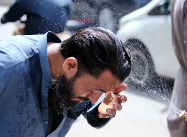 epa12934290 Un voluntario rocía agua sobre personas como refresco durante una ola de calor en Karachi, Pakistán, 5 de mayo de 2026. Se espera que Karachi permanezca caliente y seca durante las próximas 24 horas, con temperaturas inferiores a 40 grados Celsius, dijo el Departamento Meteorológico de Pakistán, luego de un pico de 44,1 grados Celsius, ya que se recomienda a los residentes que limiten la exposición y se mantengan hidratados. EPA/REHAN KHAN