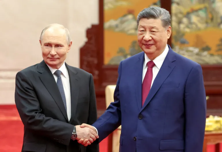 El presidente ruso Vladimir Putin y el presidente chino Xi Jinping se dan la mano mientras posan para fotos antes de una ceremonia del té después de su reunión en el Gran Salón del Pueblo en Beijing, China, el 20 de mayo de 2026. Sputnik/Alexander Kazakov/Pool vía REUTERS ATENCIÓN EDITORES: ESTA IMAGEN FUE PROPORCIONADA POR UN TERCERO.