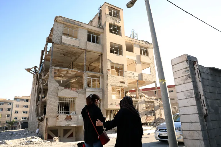 epa13011956 Mujeres iraníes caminan frente a un edificio residencial, destruido por anteriores ataques aéreos estadounidenses-israelíes, en Teherán, Irán, el 2 de junio de 2026. El Ministro de Asuntos Exteriores iraní afirmó que el acuerdo entre Irán y Estados Unidos es