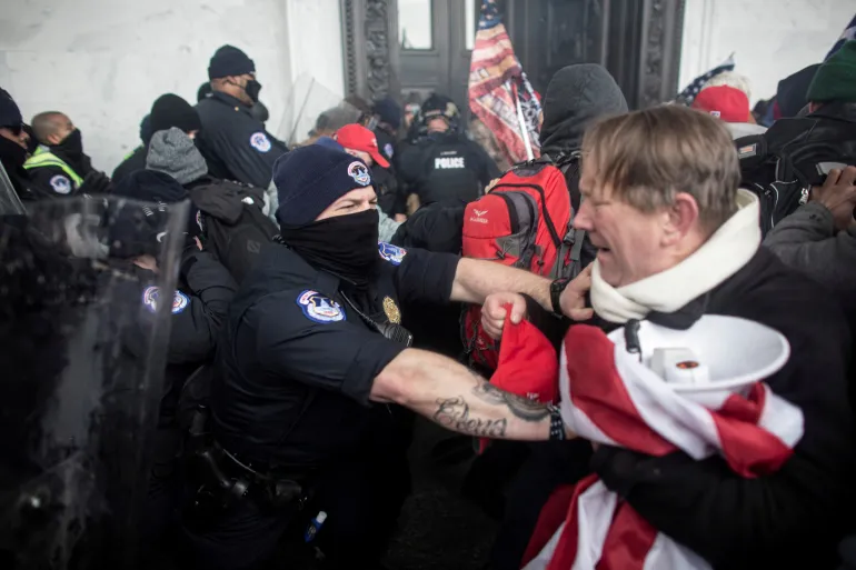 FOTO DE ARCHIVO: Miembros de las fuerzas del orden se enfrentan con manifestantes pro-Trump, que irrumpieron en el Capitolio de EE. UU. durante una manifestación para impugnar la certificación de los resultados de las elecciones presidenciales de EE. UU. de 2020 por parte del Congreso de EE. UU., en el edificio del Capitolio de EE. UU. en Washington, DC, EE. UU., el 6 de enero de 2021. Fotografía tomada el 6 de enero de 2021. REUTERS/Ahmed Gaber./Foto de archivo